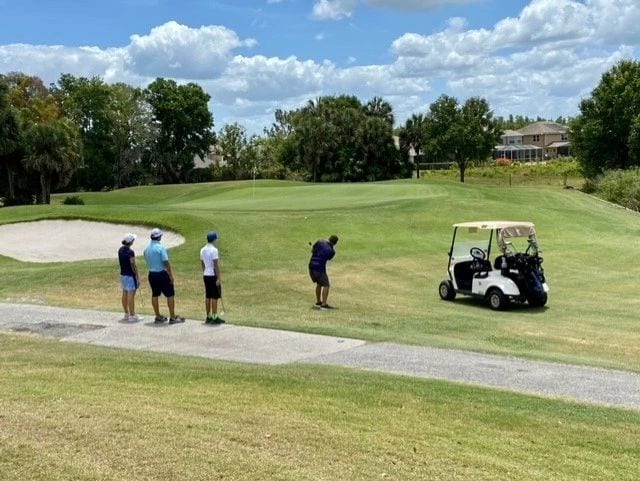 four men playing golf